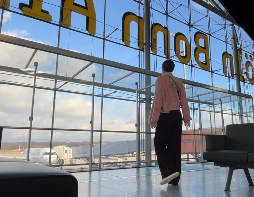 Jennilee at the airport wide shot of Jennilee at the airport, walking away from camera toward a large window